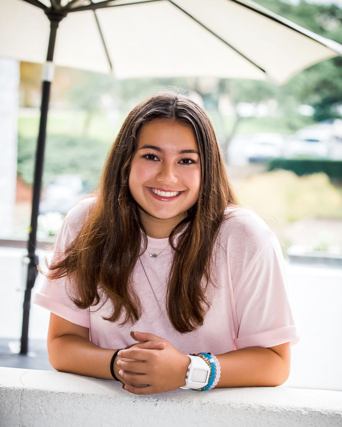 Smiling teen wearing braces and Invisalign, orthodontic treatment options.